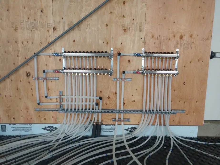 Two radiant heating manifolds with PEX loops dropping to the slab