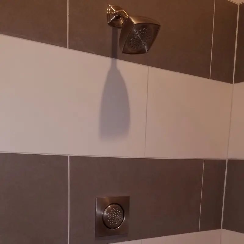 Square rain shower head and body spray in banded tile