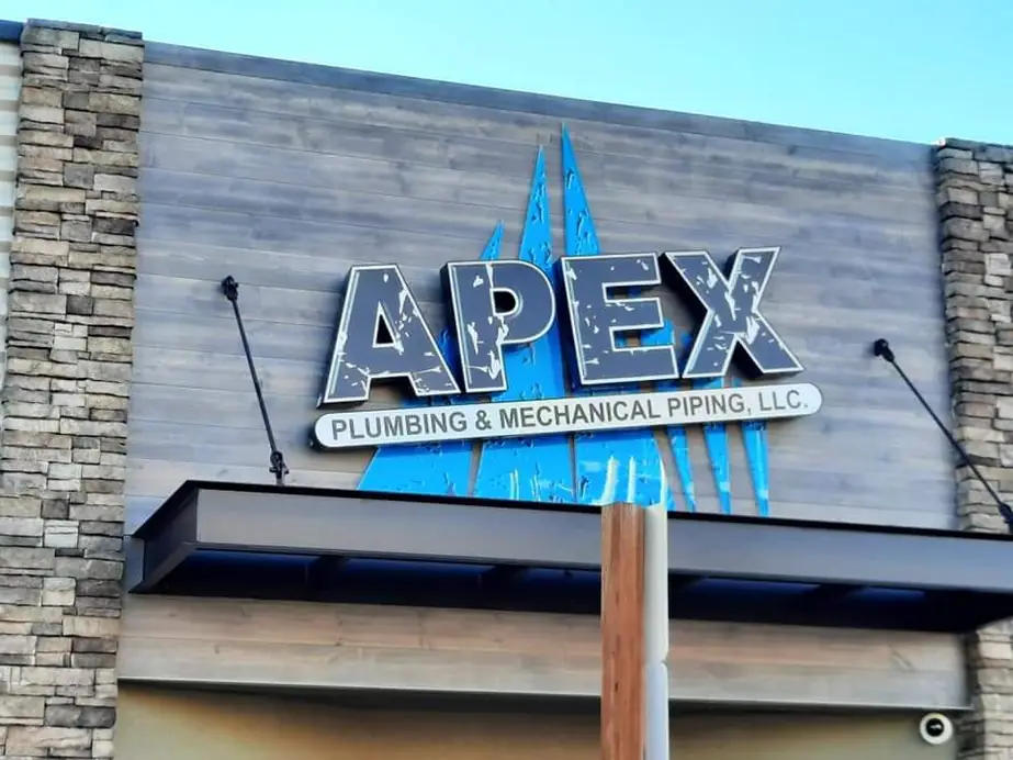 The lit Apex Plumbing & Mechanical Piping sign on the office facade at 12 South 3rd Avenue, Yakima