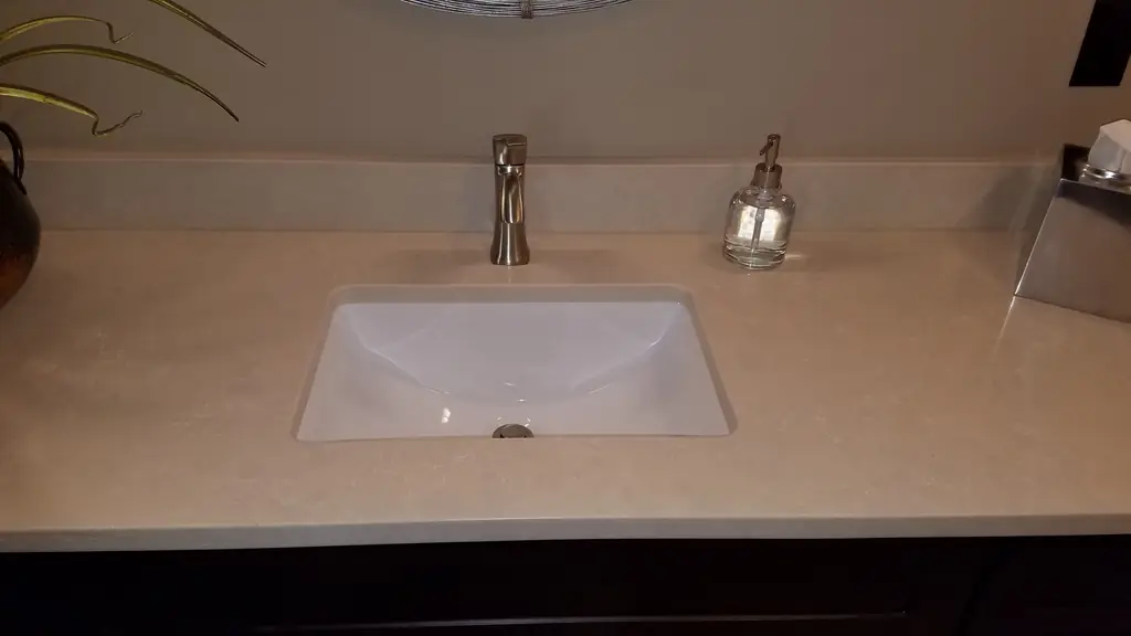 White undermount vanity sink with a brushed faucet on a quartz top